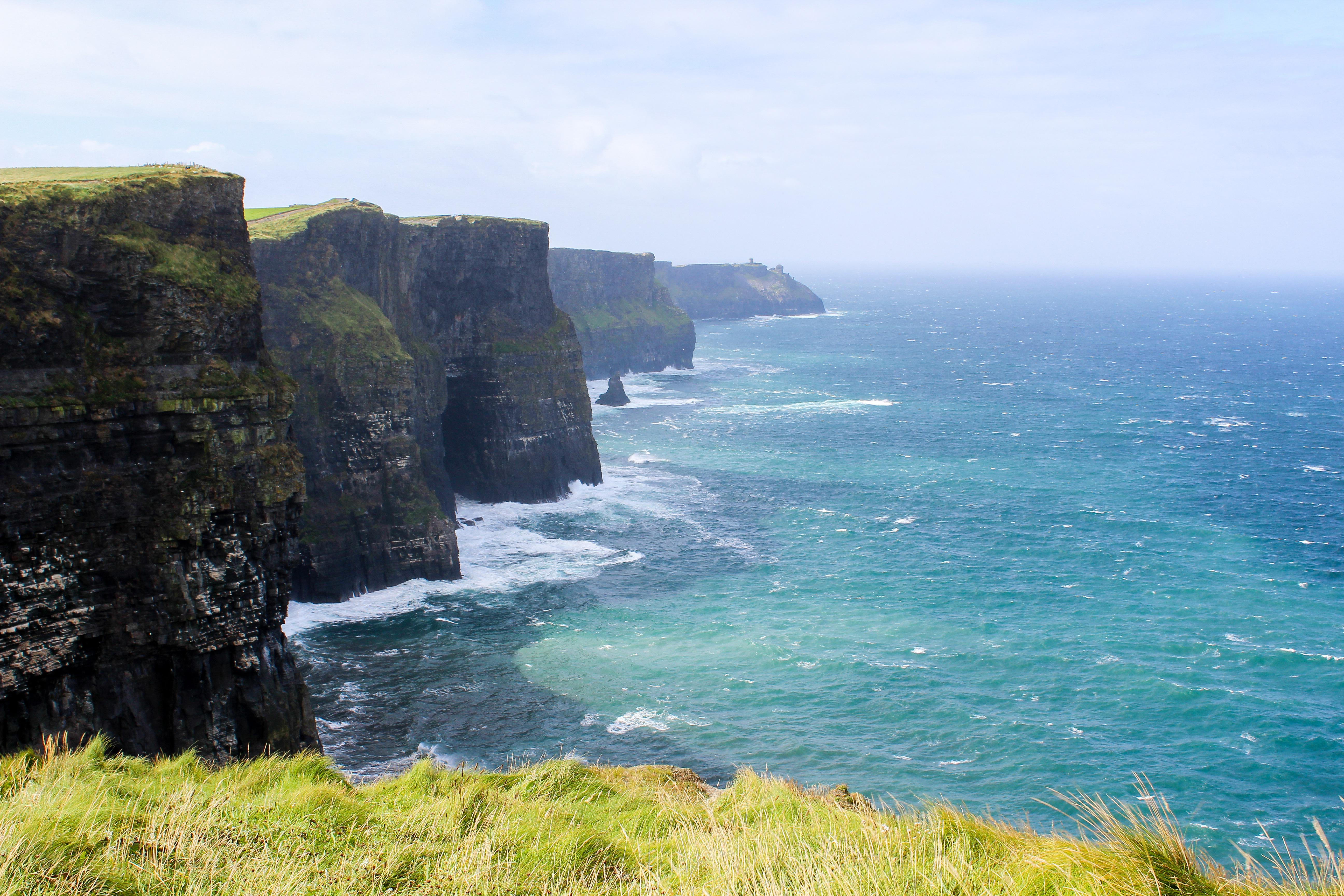 Irské útesy a angličtina s akcentem Útesy Cliffs of Moher v Irsku nad Atlantikem jako symbol irského akcentu a business angličtiny.